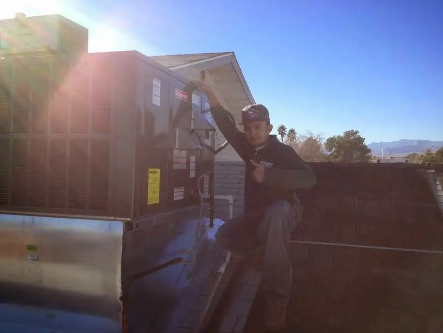 HVAC technician performing AC Tune-Up on a rooftop unit in New Richmond